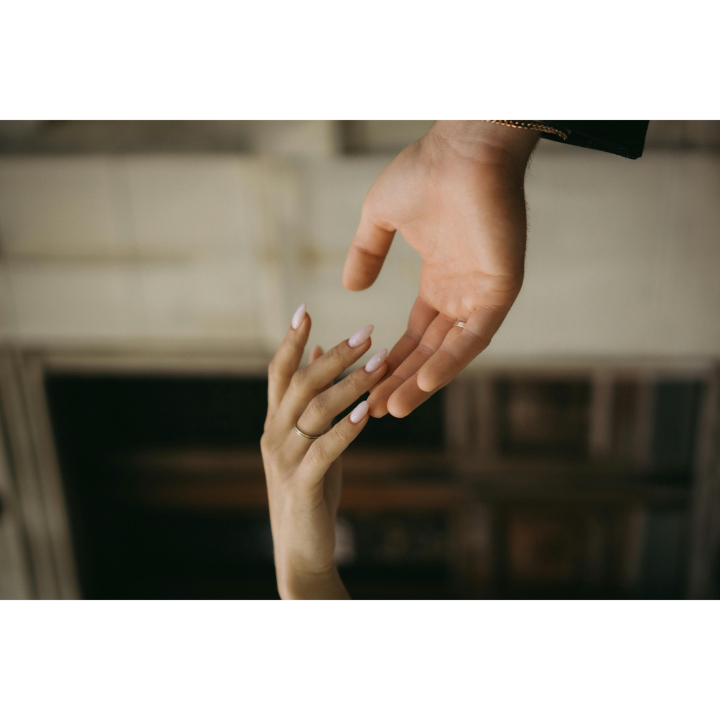 Main de mariée avec manucure élégante, tenue par la main du partenaire lors d’un moment romantique.